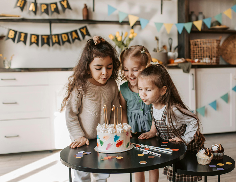 Little girls blowing candles on a birthday cake